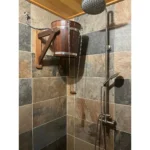 TESLI 20 L thermo ash sauna shower bucket with plastic insert, installed on a tiled shower wall
