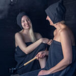 Rento Black sauna ladle with heat-treated bamboo handle in a sauna setting